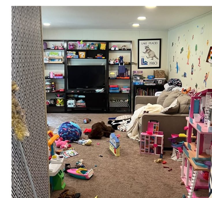 The same playroom before cleaning, with toys and clutter across the floor